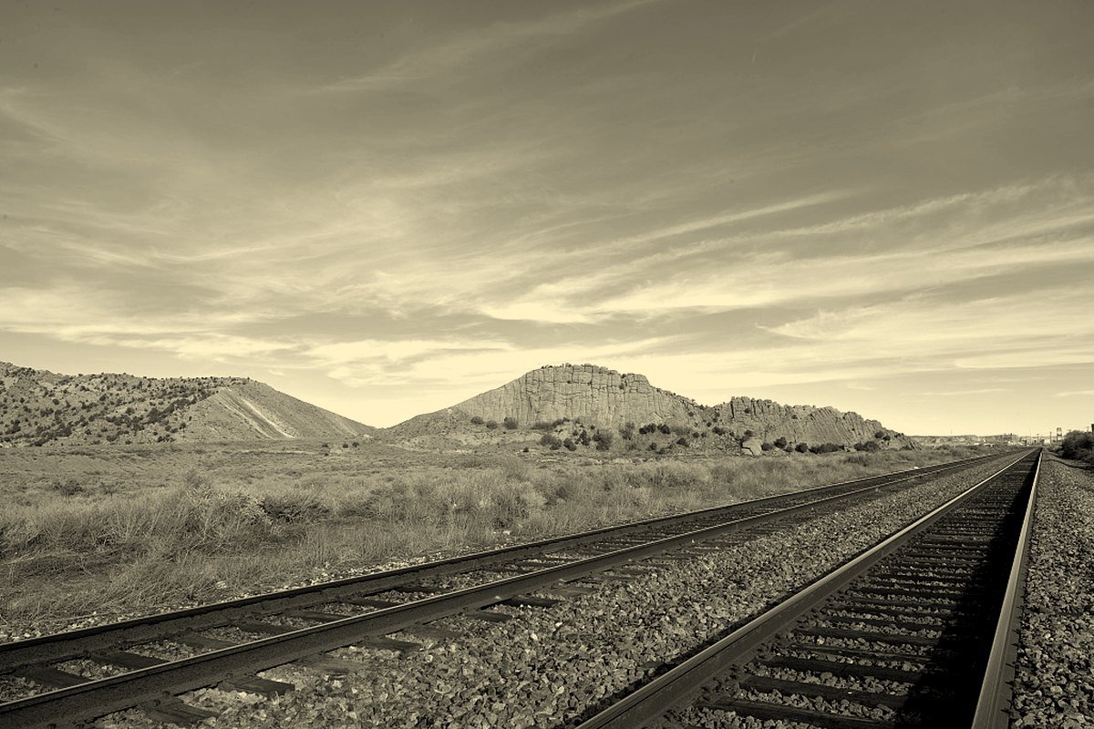 Railroad tracks running straight toward the horizon across the high desert near Gallup, New Mexico